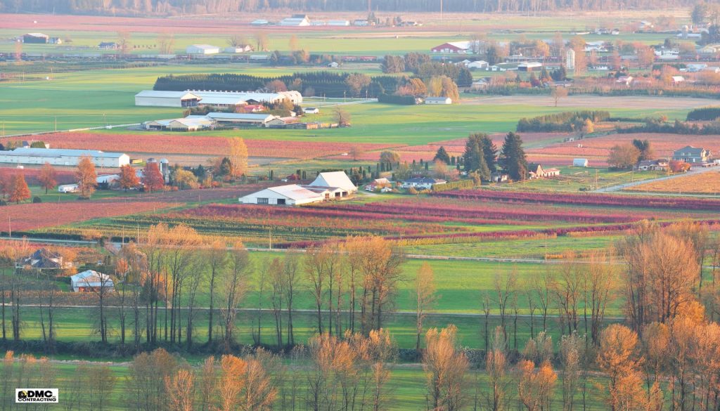 Fraser Valley landscape showcasing agricultural fields, farms, and autumn foliage, reflecting the region's rural charm and potential for custom home building by DMC Contracting.